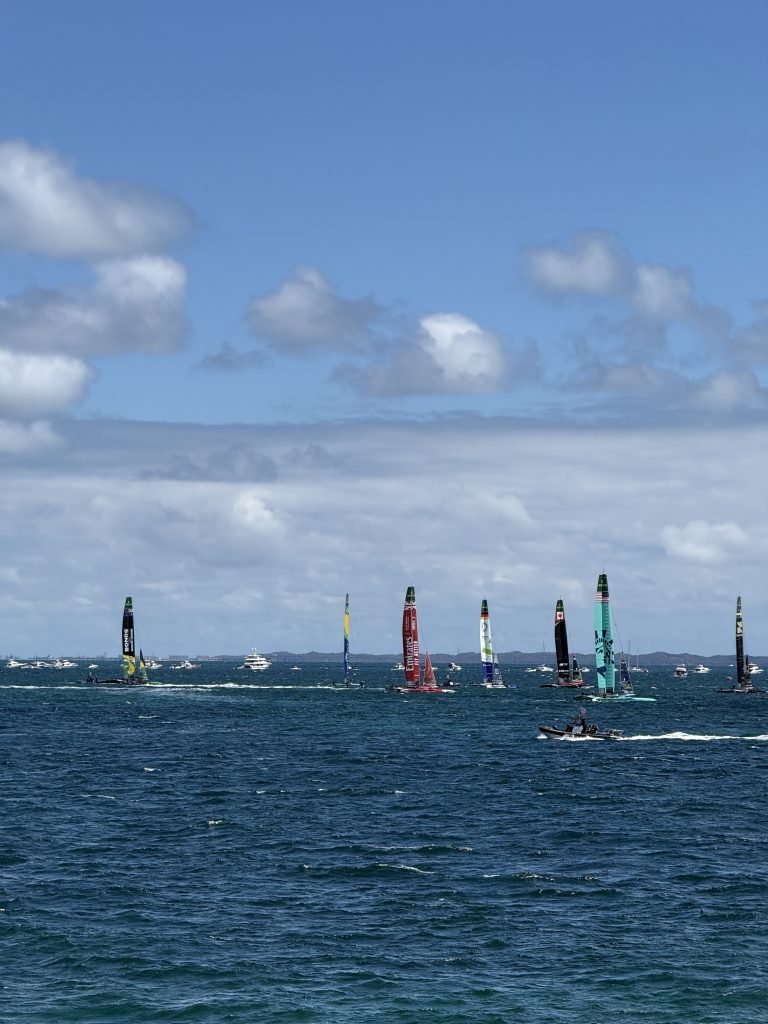 The SailGP fleet of F50 catamarans spread across the water during racing at the 2026 Perth Sail Grand Prix, seen from the shore