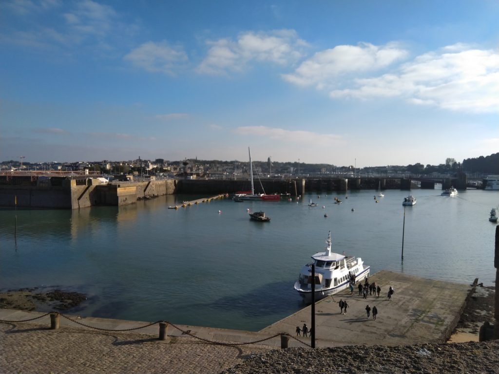 Francis Joyon's ocean racing trimaran IDEC SPORT alongside in Saint-Malo, its red and white central hull and crossbeams seen from the quay