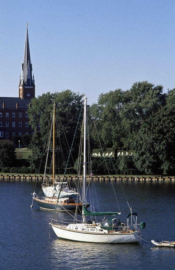 Sailing yachts moored on Spa Creek at Annapolis, Maryland, seen across the water with the shoreline and trees behind